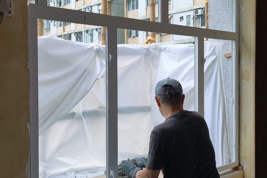 工人為公屋單位安裝符合屋宇署標準的新鋁窗框工程